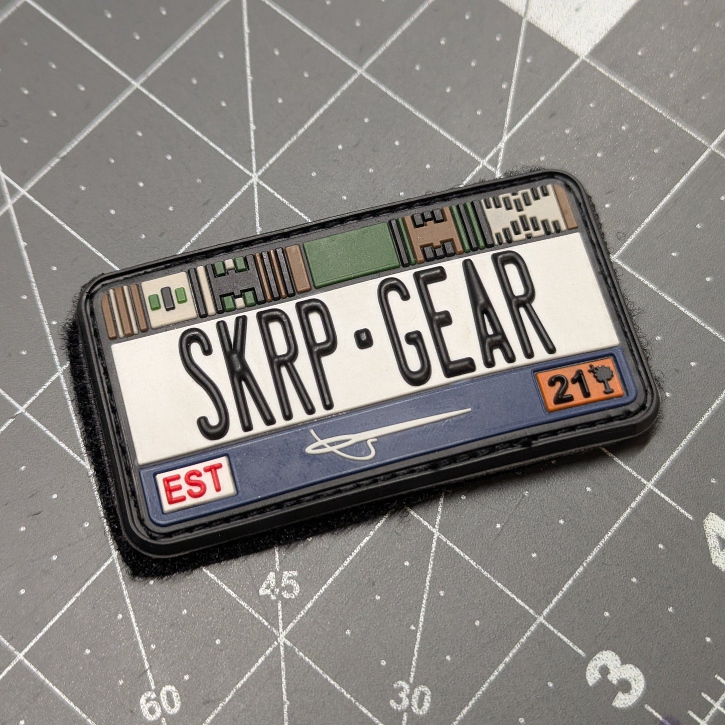 Patch with 'SKRP GEAR' text on a gray cutting mat